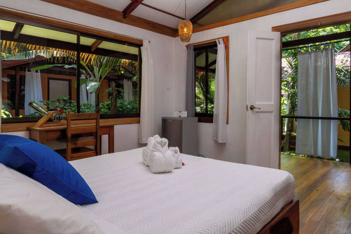 A bedroom with a bed, a desk, and a chair.