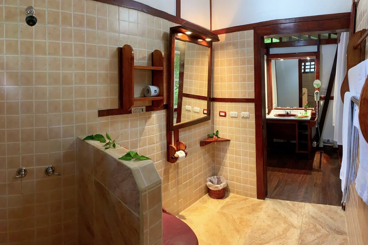 A bathroom with a shower, a sink, a mirror, and a towel rack.