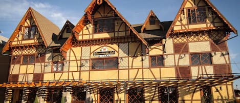 A traditional half-timbered building with a sign reading "Encantos do Sul."