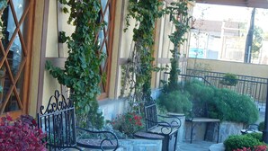 An outdoor seating area with stone tables and benches, surrounded by greenery and decorative plants. - Life Hotel Infinity (Gramado)