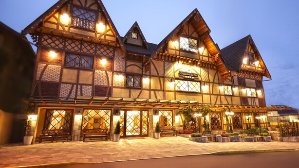 A traditional European-style building with a sign reading "Enclosed Hall." It features a symmetrical facade with multiple windows and a central entrance. - Life Hotel Infinity (Gramado)