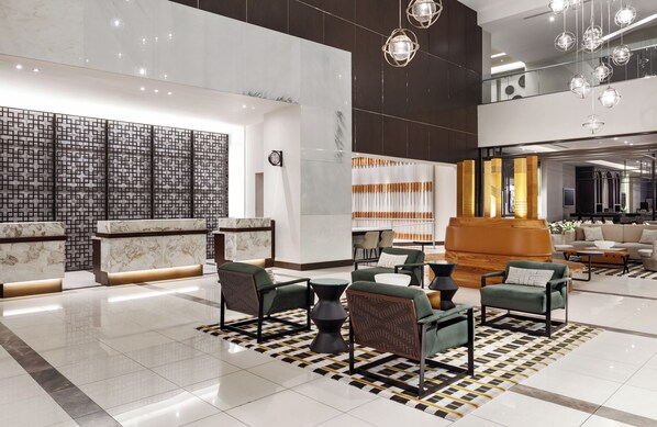 A modern lobby with a reception desk, seating area, and a staircase leading to an upper level. - Marriott Panama Hotel (Panama City)