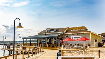 A waterfront restaurant with outdoor seating and a wooden deck.