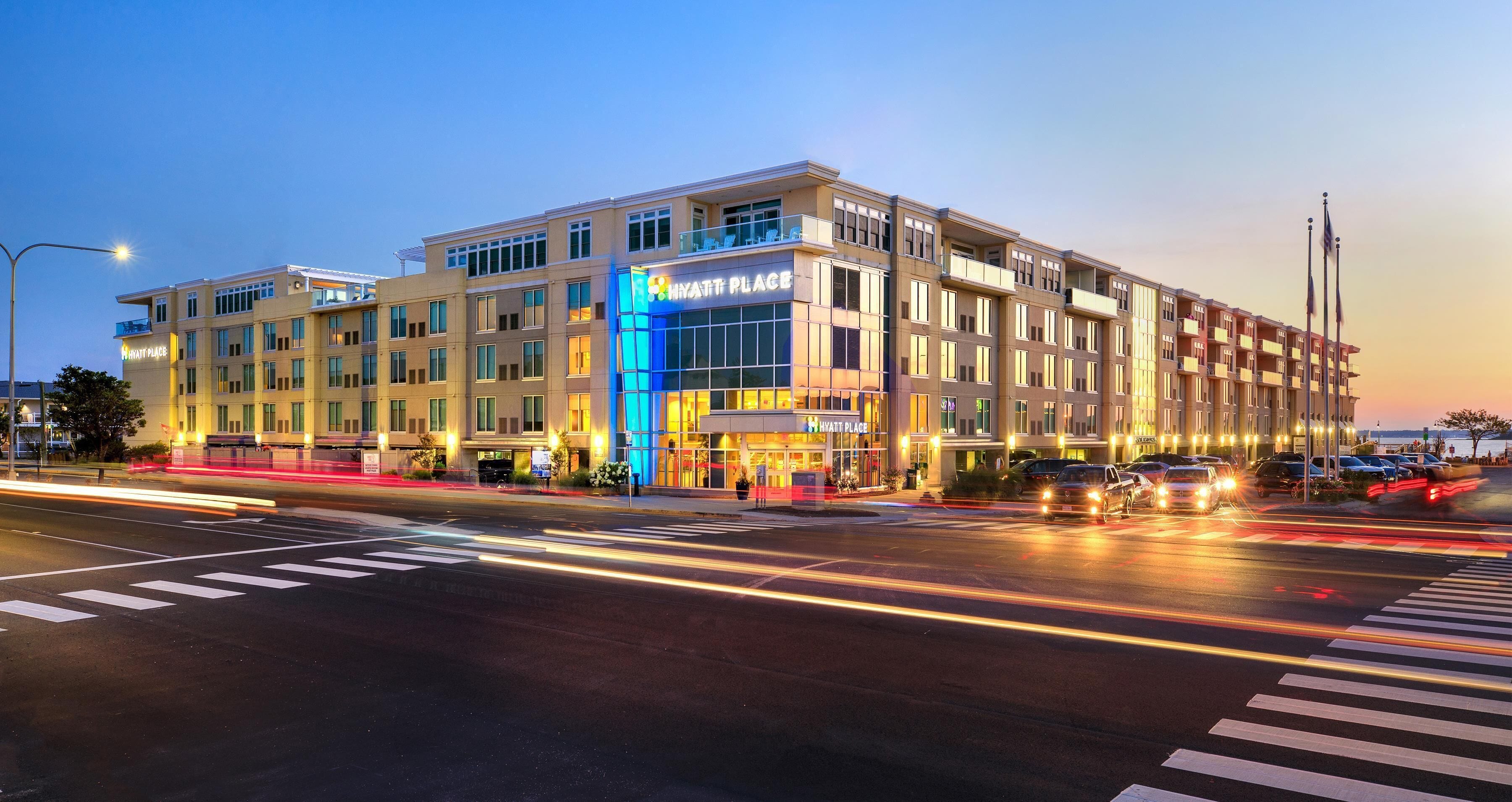 A multi-story hotel with a prominent 'Hyatt Place' sign, a modern architectural design, and a well-lit facade.