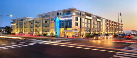 A multi-story hotel with a prominent 'Hyatt Place' sign, a modern architectural design, and a well-lit facade.
