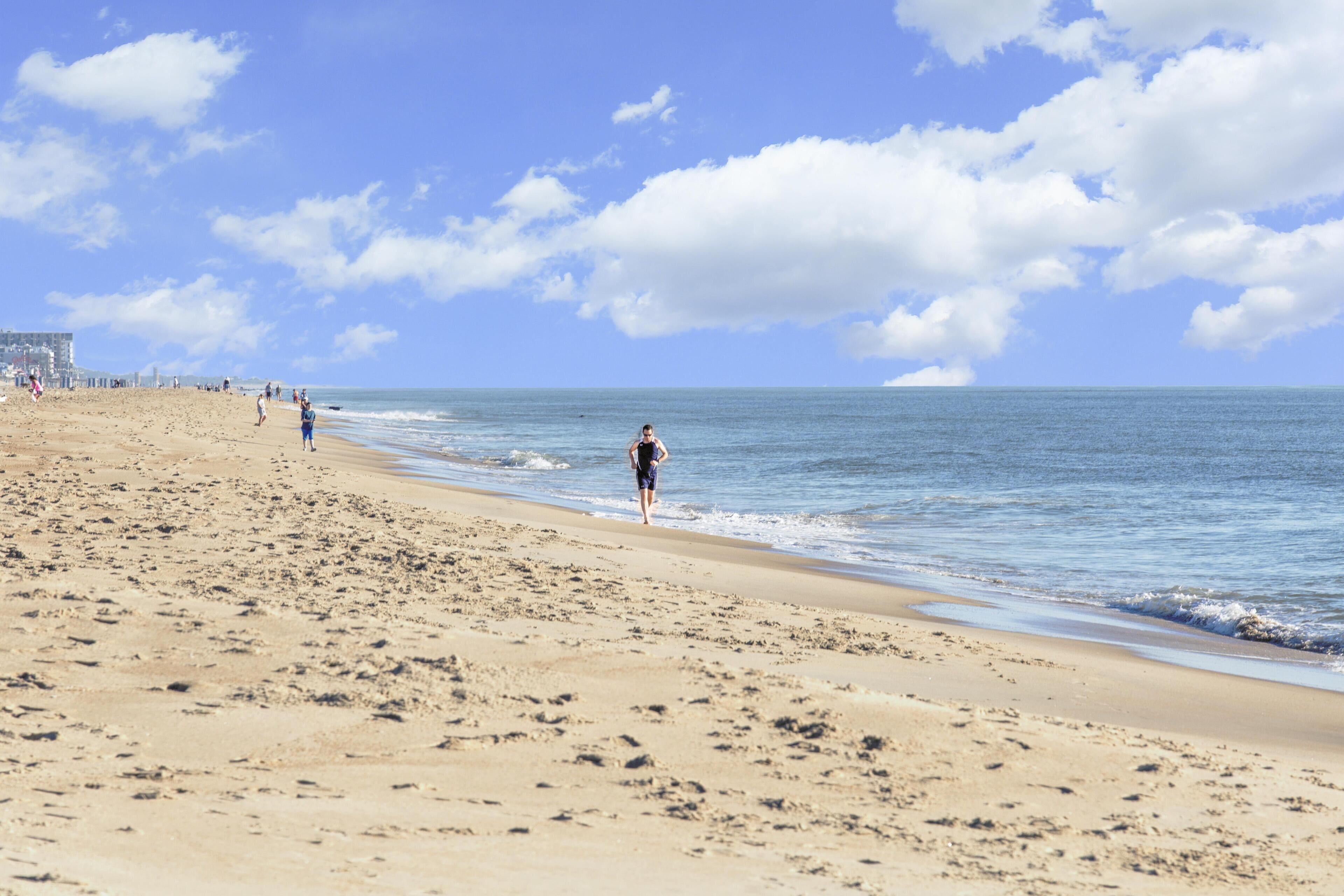 Una playa con cielo despejado y mar tranquilo.