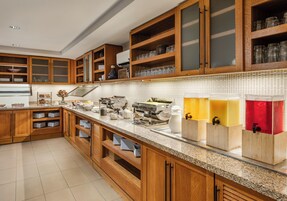 A kitchen with wooden cabinets, a granite countertop, and various kitchen appliances.