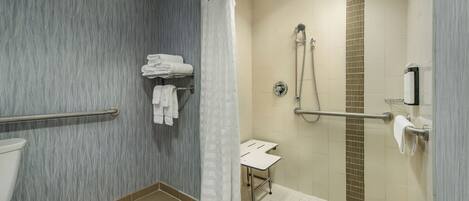 Un baño moderno con ducha, inodoro y barra para toallas.