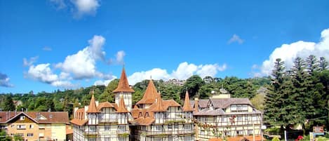 A traditional half-timbered building with multiple stories, a prominent tower, and a sign indicating it is a hotel.