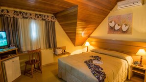 Une pièce confortable avec un lit, deux lampes de chevet, un bureau avec un ordinateur et une chaise.