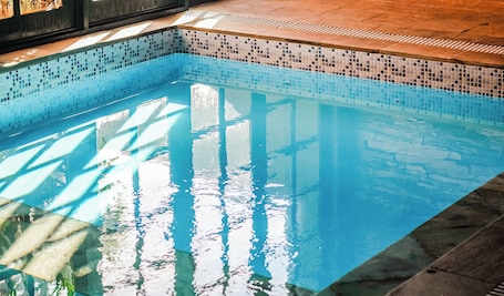 Una piscina techada, sillones reclinables de piscina