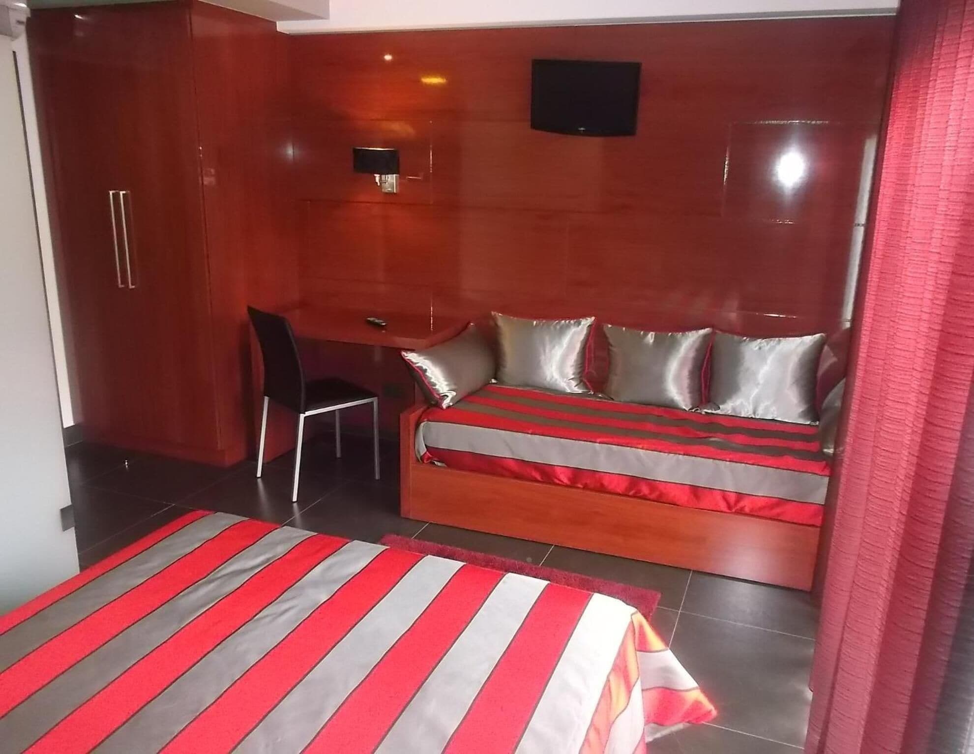 Un dormitorio con cama, escritorio y armario.