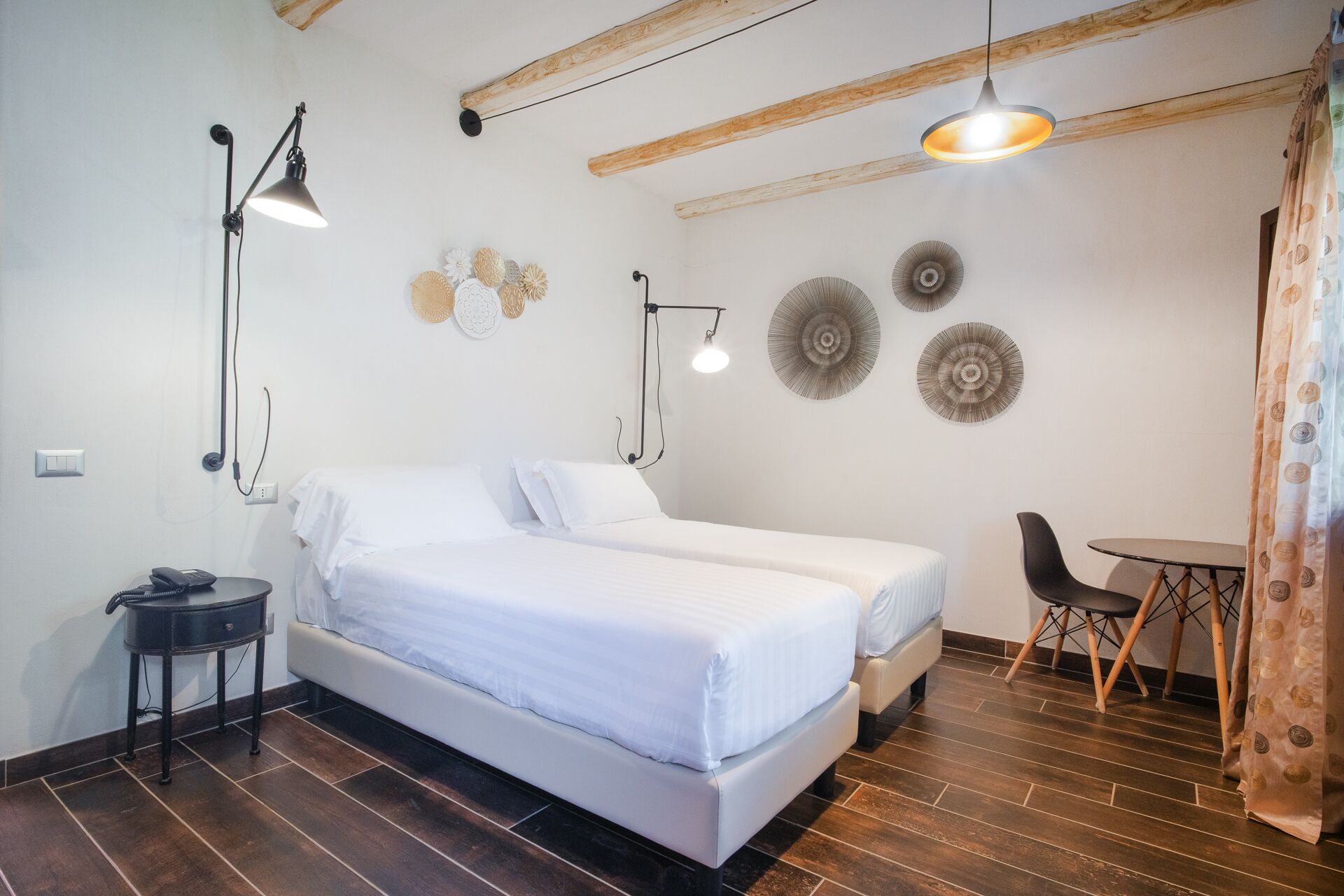 Un dormitorio con cama, mesita de noche, lámpara y decoración en la pared.