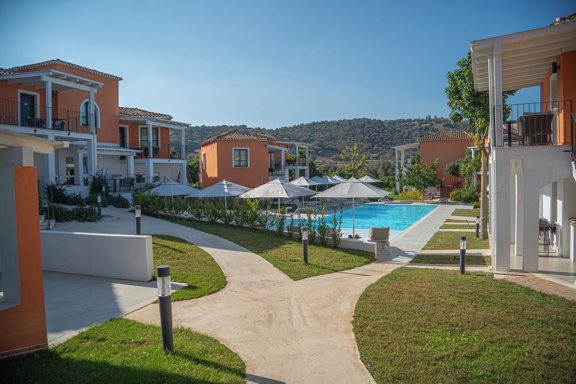 Et resort med swimmingpool, udendørs siddepladser og udsigt til bakkerne.
