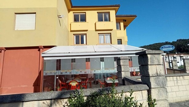 A hotel with a reception area, outdoor seating, and a clear view of the surrounding buildings. - Hotel Costa Cántabra (Argonos)