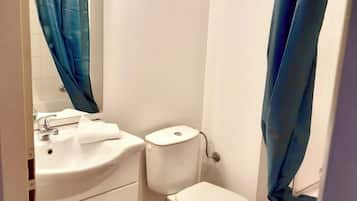 A bathroom with a white sink, toilet, and blue shower curtain.