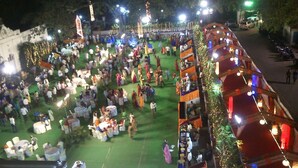 A crowded outdoor event with tables and people. - The Viceroy Comforts (Mysore)