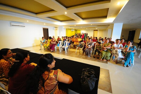 A conference room with rows of chairs facing a stage.