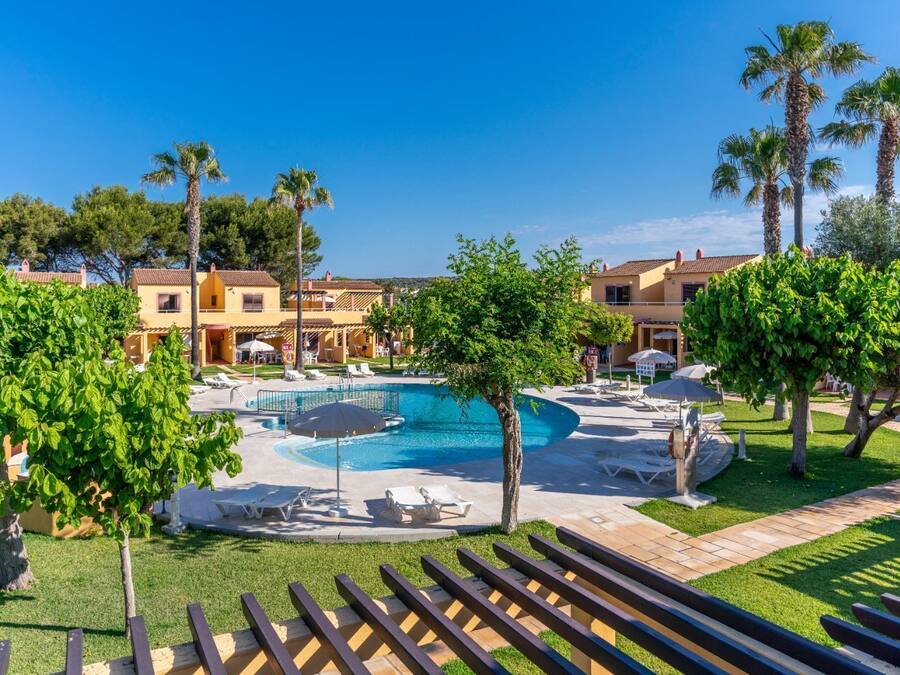 Una piscina al aire libre, sombrillas, tumbonas