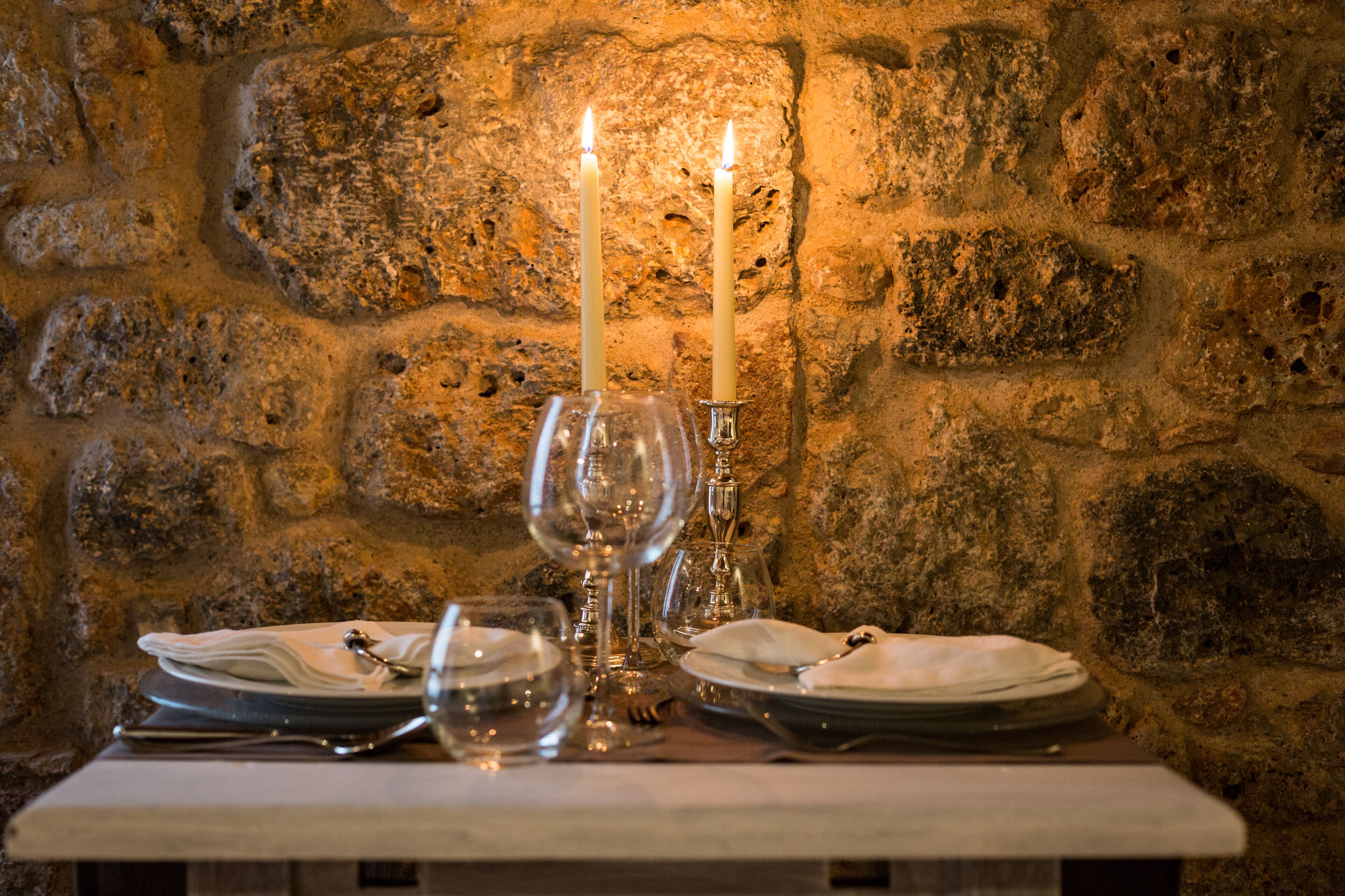 A table set with plates, glasses, and a candle.