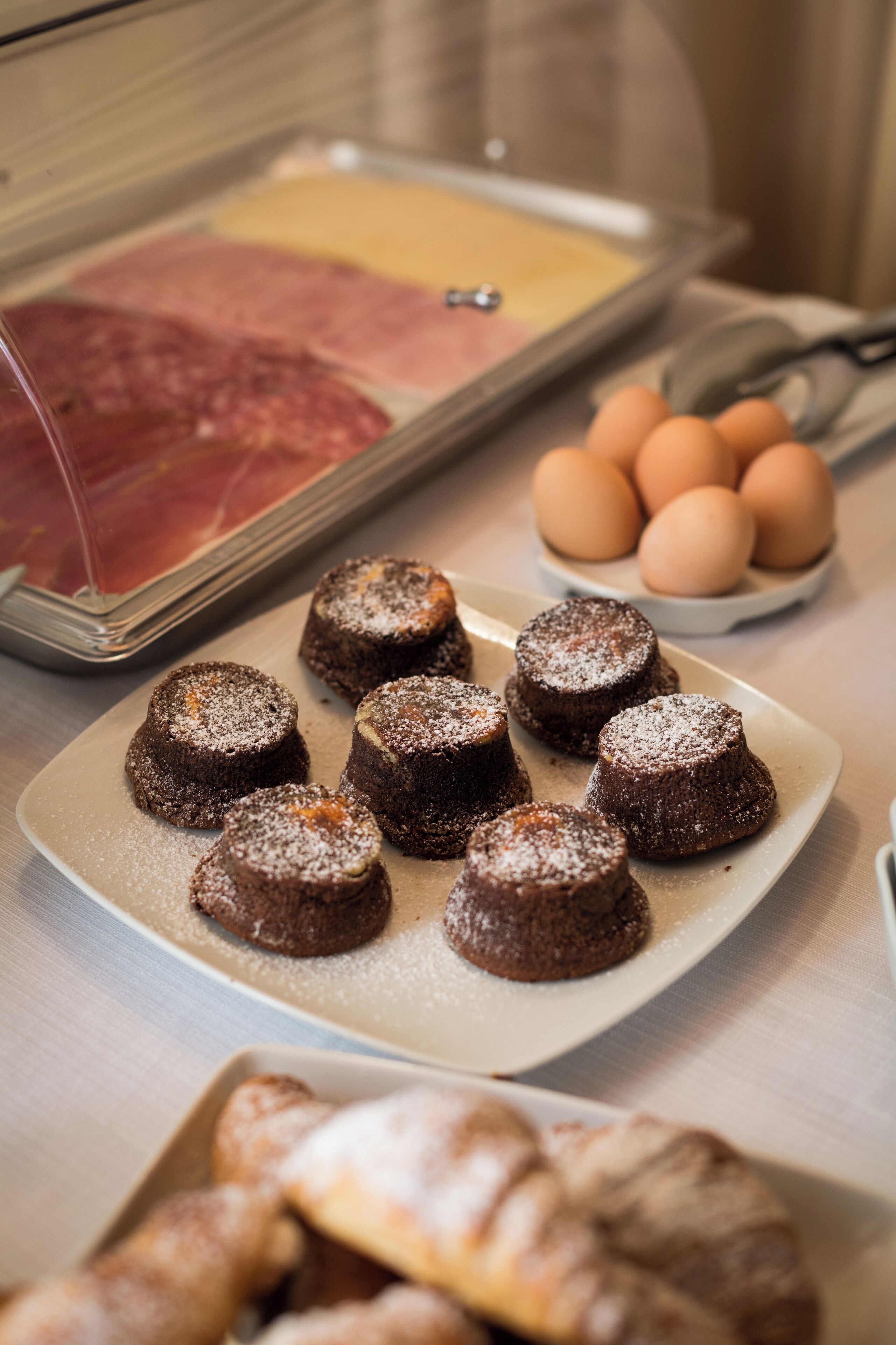 Ein Frühstücksbuffet mit verschiedenen Speisen, darunter Backwaren, Eier und Fleisch.