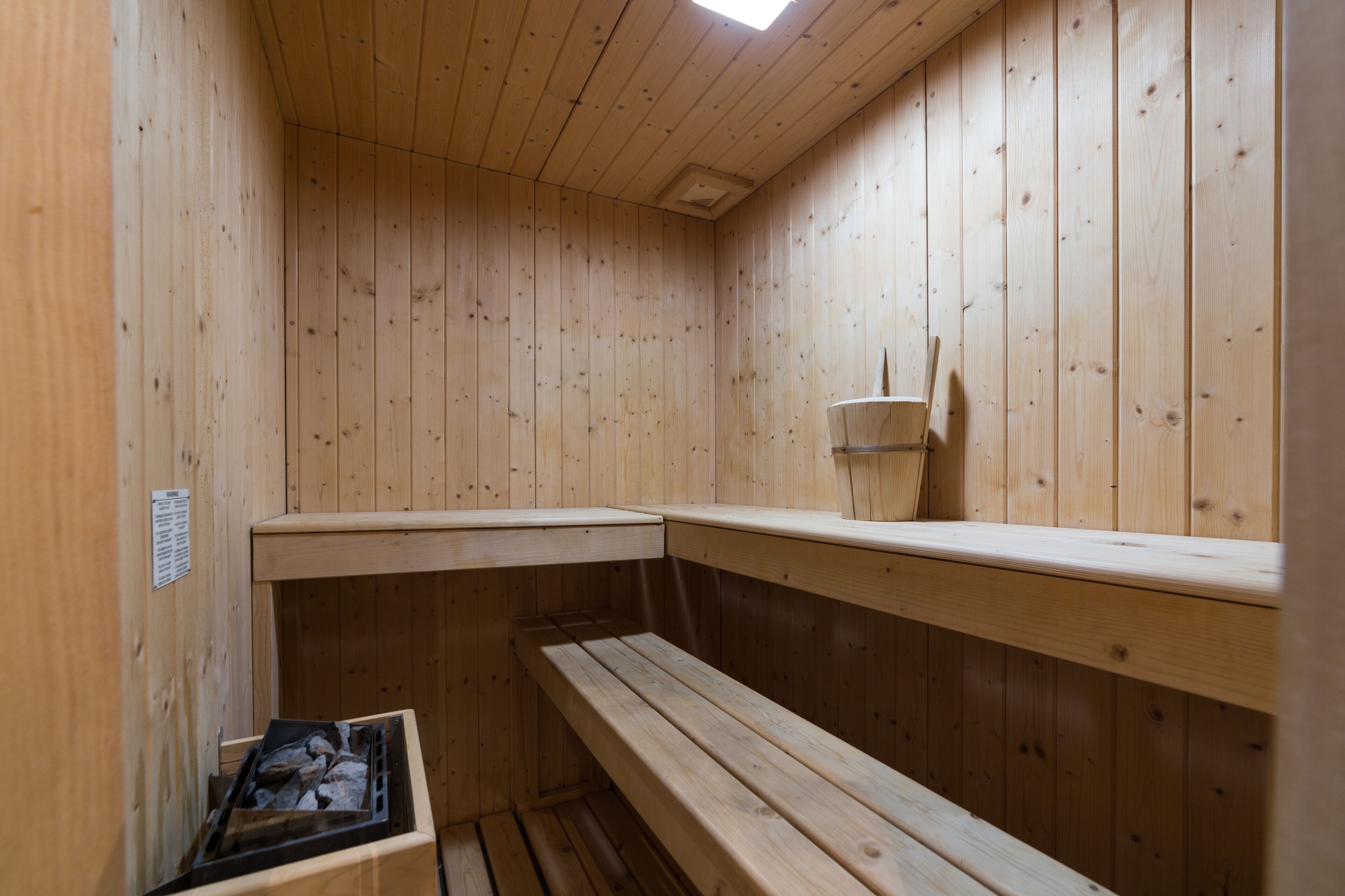 Eine Holzsauna mit Bänken und einer kleinen Ablagefläche.