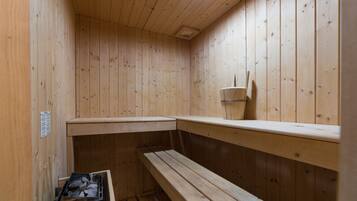 Eine Holzsauna mit Bänken und einer kleinen Ablagefläche.