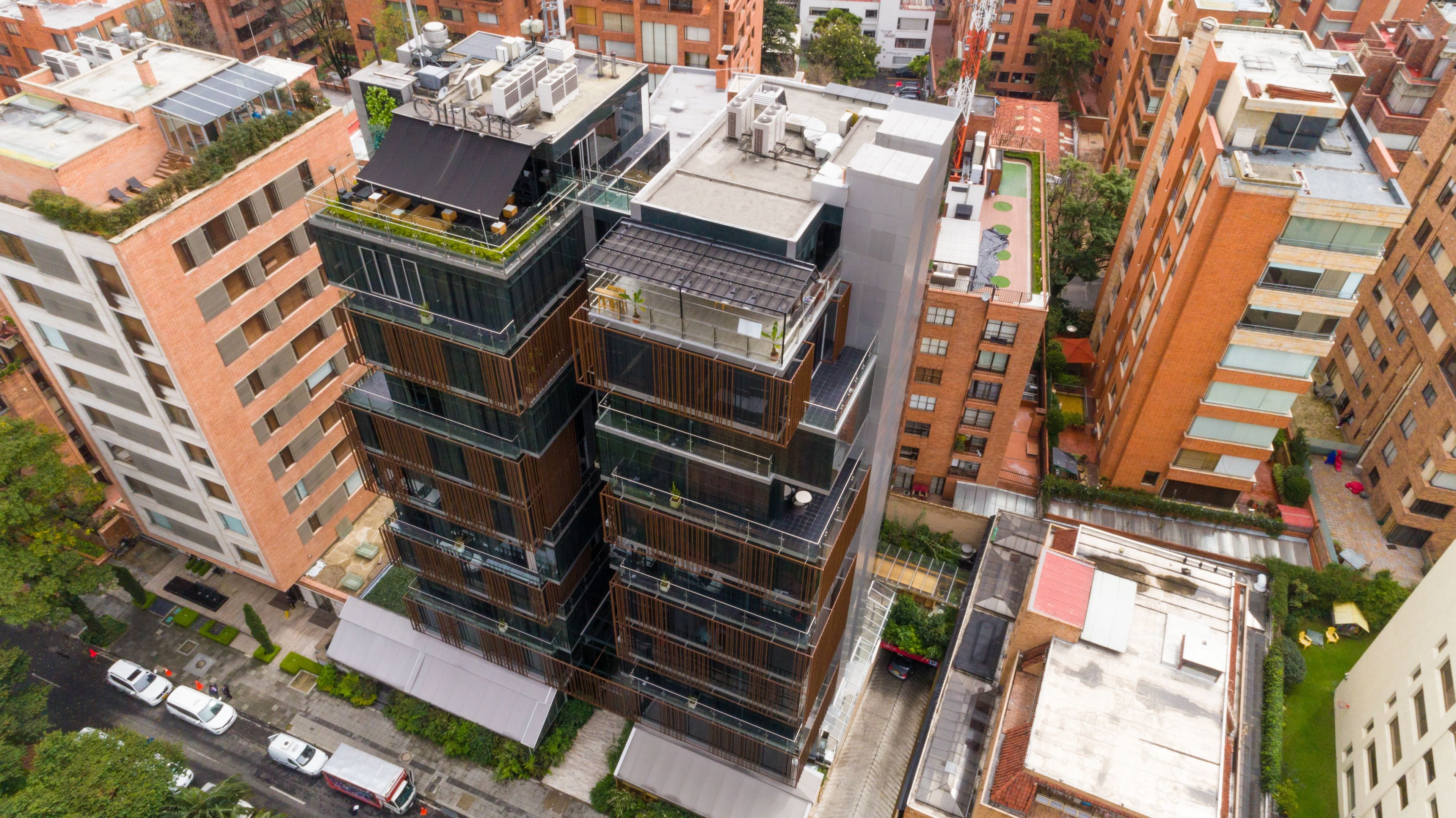 A multi-story building with a modern architectural design, featuring balconies and large windows.