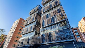 Un edificio moderno de varios pisos con fachada de vidrio y una combinación de elementos de ladrillo y metal.