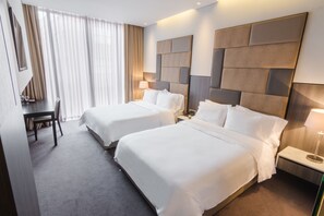 Een hotelkamer met twee bedden, een bureau en een stoel.