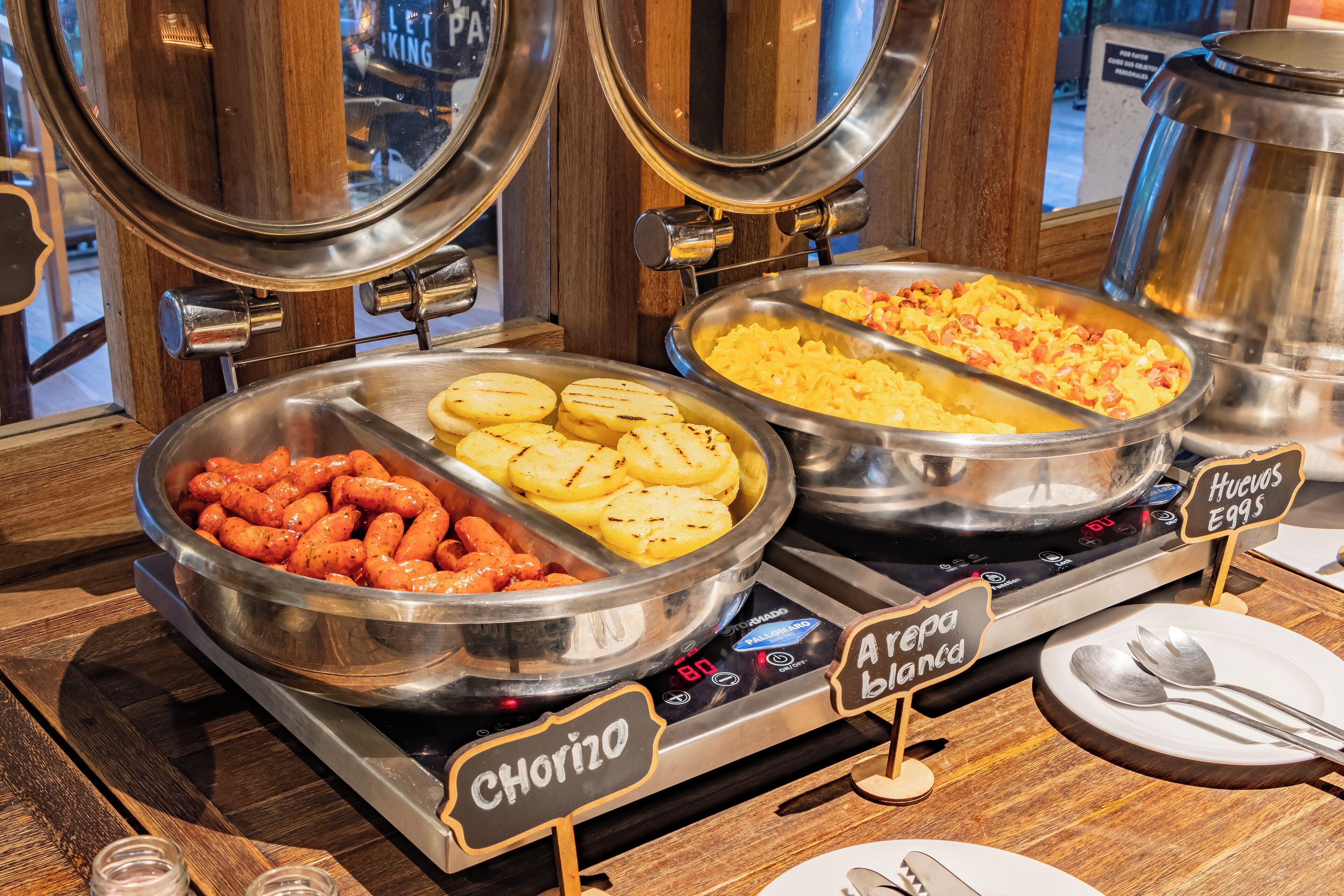 Buffet com seções identificadas para chouriço, uma loira e huevos rancheros.