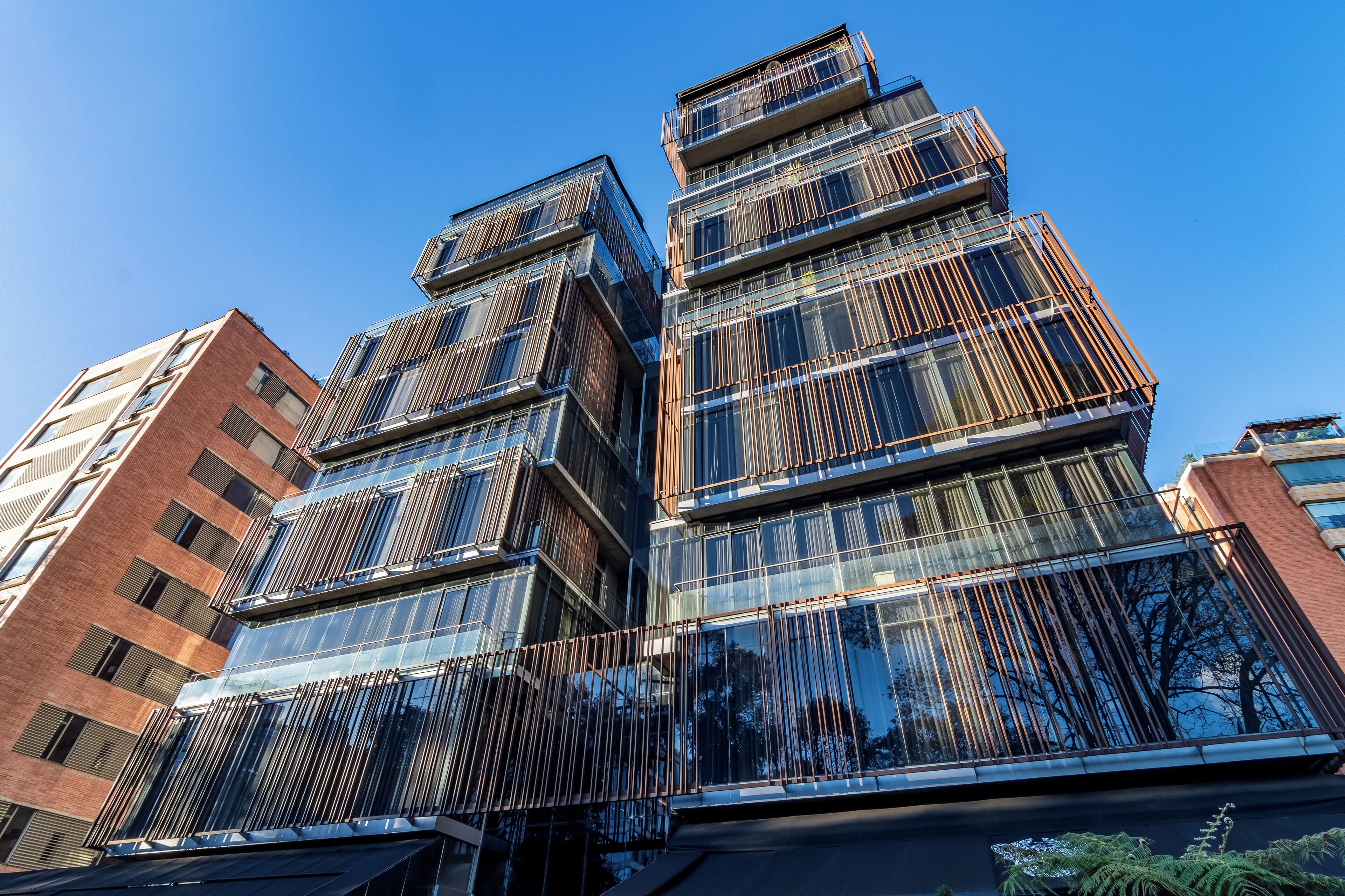 Un immeuble à étages doté d’une architecture moderne, caractérisé par de grandes fenêtres en verre et une façade structurée.