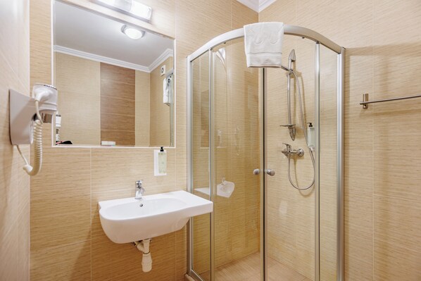 A modern bathroom with a glass-enclosed shower, a white sink, and a mirror above the sink. - Hotel Cristal Park (Dabrowa Tarnowska)