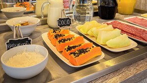 A buffet with various food items and beverages, including a sign for 'COCO' and a bowl of rice. - Pousada Serra Valle (Gramado)