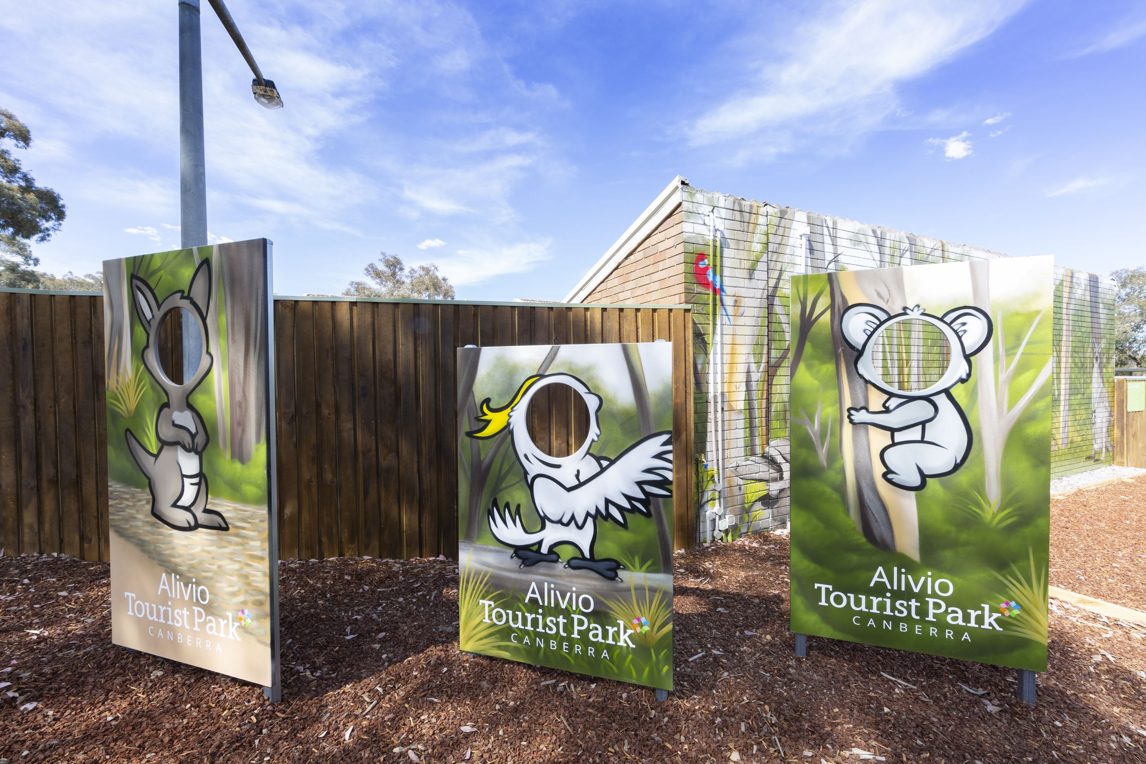 Tres carteles de Alivio Tourist Park con ilustraciones de canguros y aves.