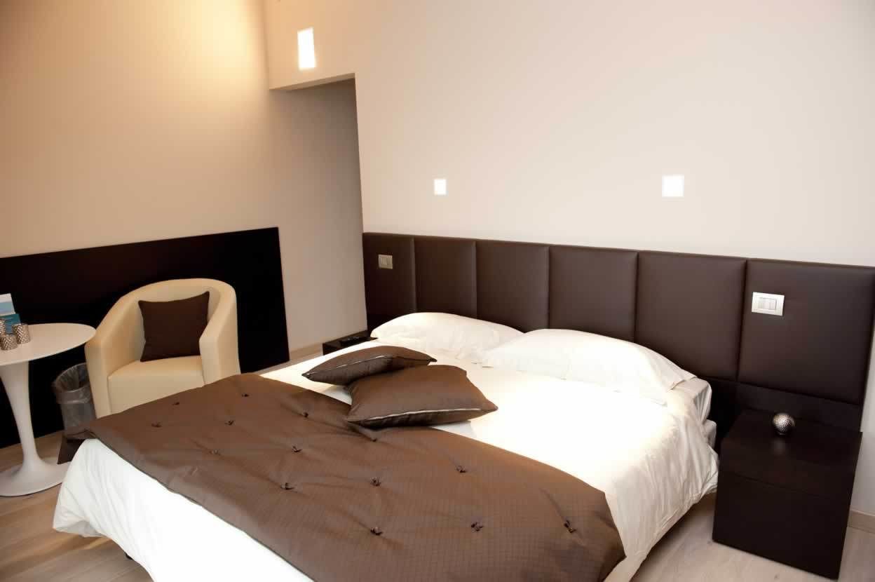 Une chambre d’hôtel moderne avec un grand lit, une table de chevet, une chaise et une petite table.
