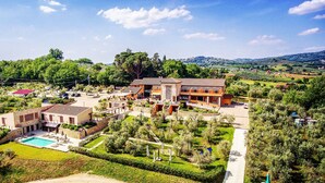 Uma grande propriedade com vários edifícios, piscina e jardins bem cuidados.