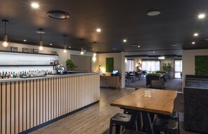 A modern restaurant with a bar area, wooden tables, and chairs. - Zig Zag Motel (Lithgow)