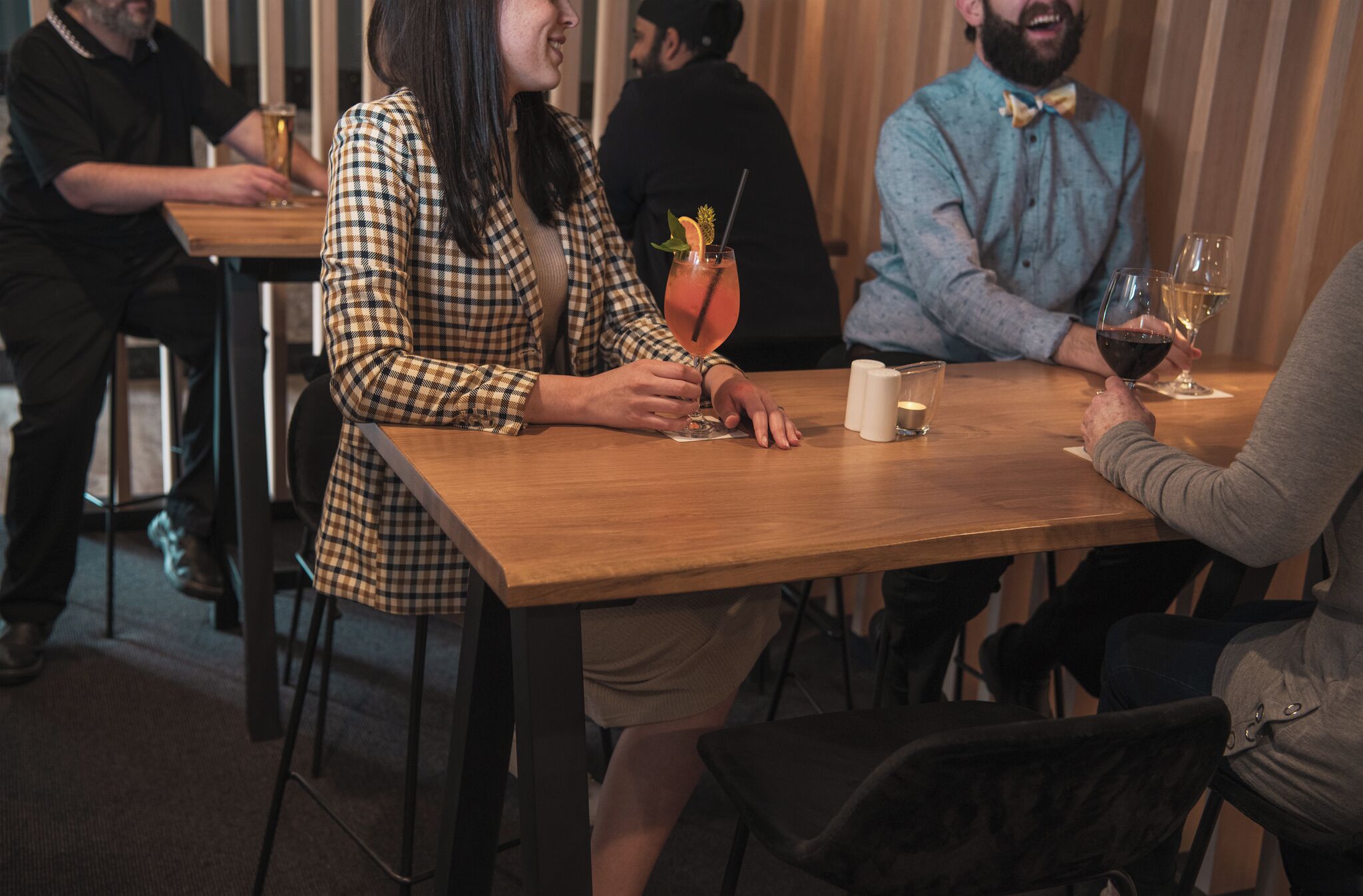 Un grupo de personas sentadas en una mesa de madera en un restaurante con ambiente relajado.