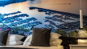 A bed with pillows and a view of a marina with boats. - Partenope Relais (Naples)
