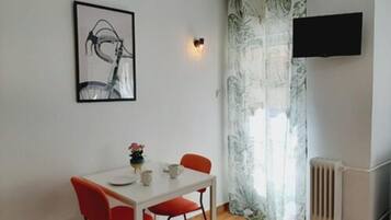 Enjoy a romantic dinner for two at this cozy room, featuring a table set with a flat-screen TV and a radiator for warmth.