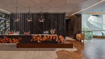 A modern bar area with a long counter, multiple hanging lights, and a decorative centerpiece.