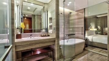 A modern bathroom with a glass-enclosed shower, a large mirror, and a bathtub.
