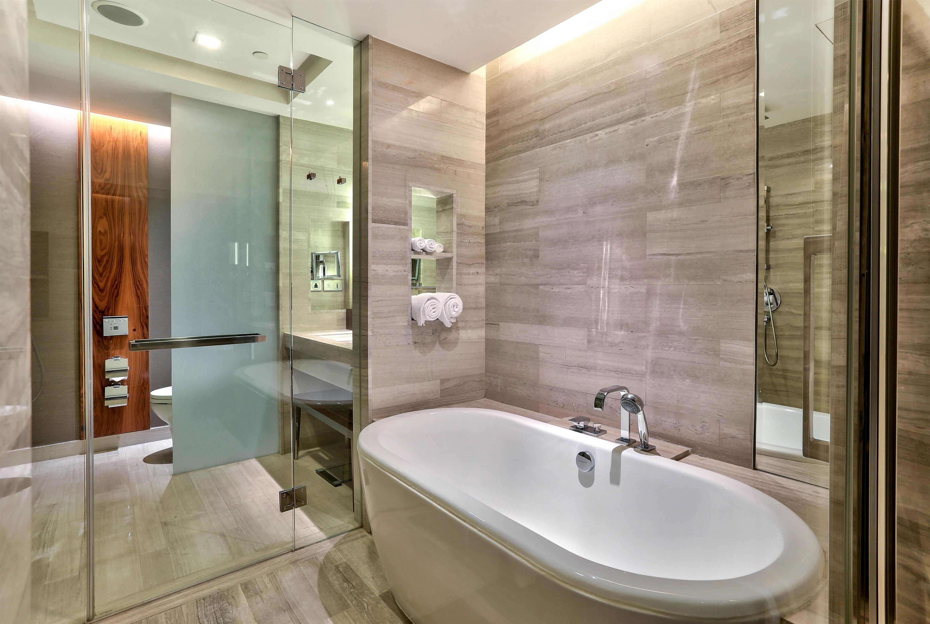 Une salle de bain moderne avec une baignoire sur pieds, une douche à parois de verre et un meuble-lavabo avec un miroir.