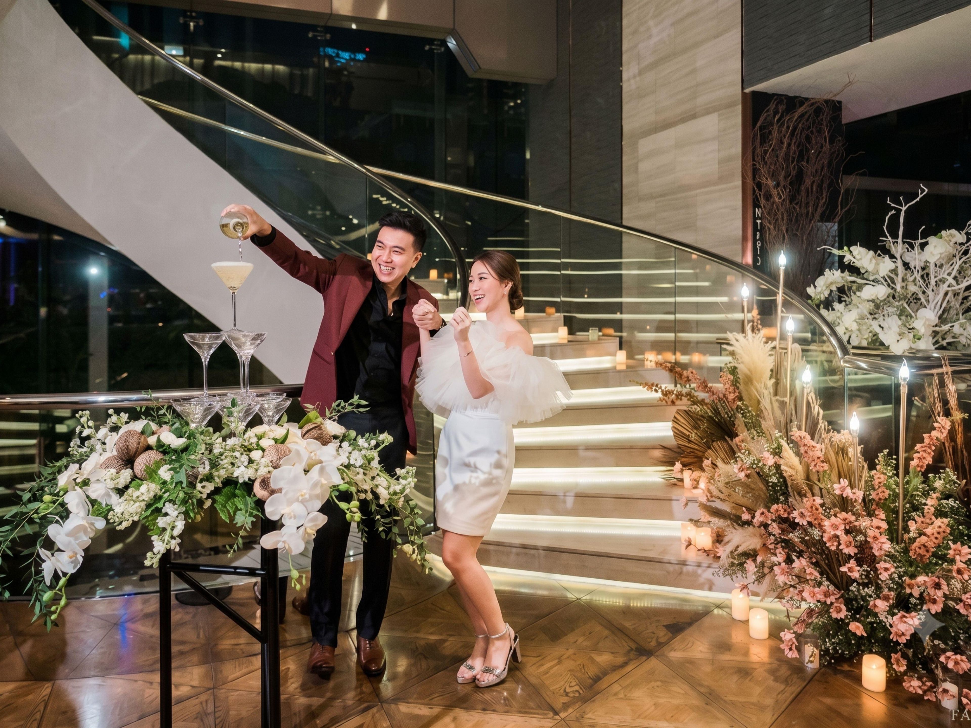 A staircase with a railing, a table with floral arrangements, and a glass railing.
