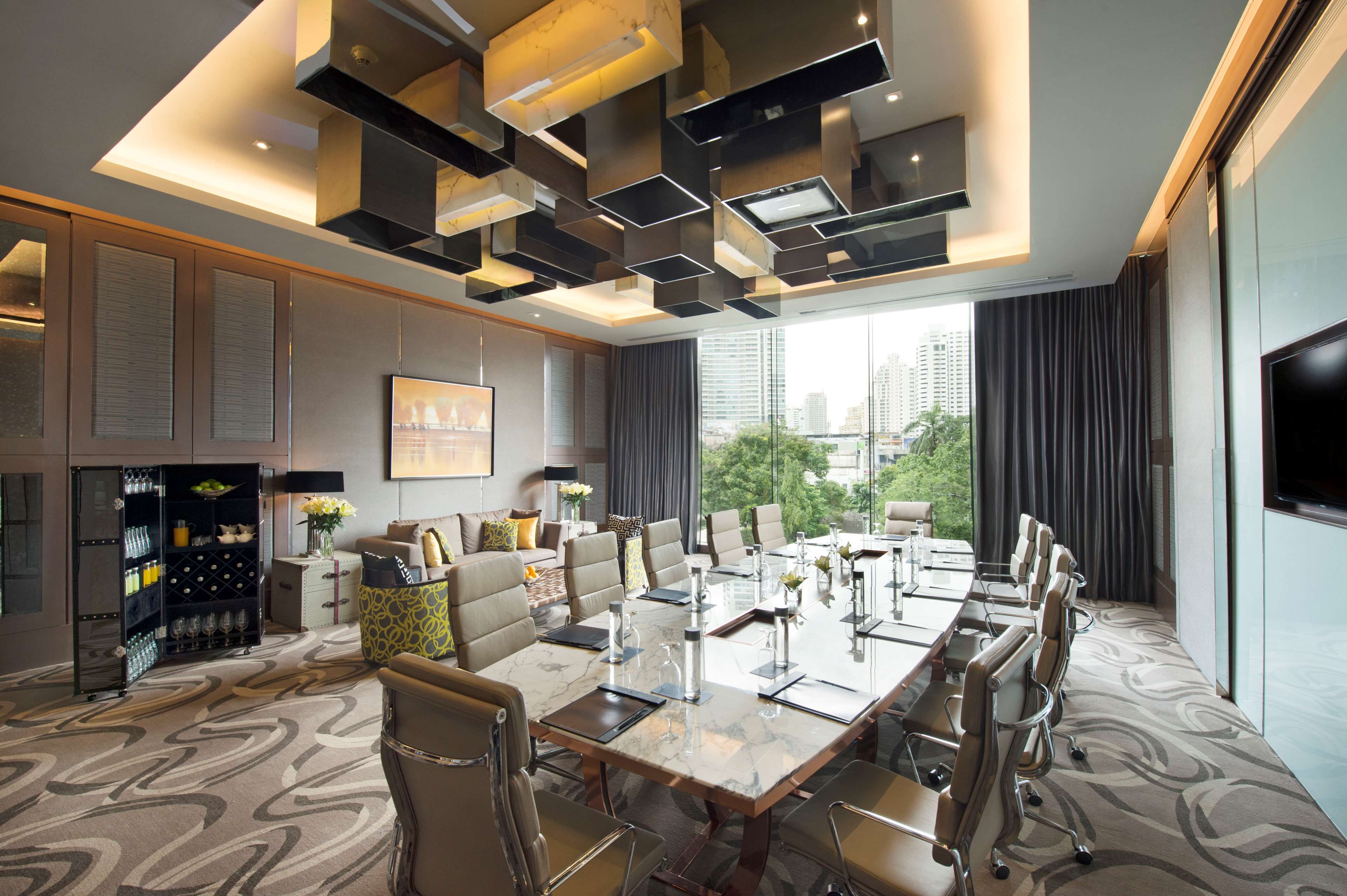 A modern conference room with a large table, chairs, and a city view.