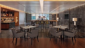 Un espace repas moderne doté d’un bar central, d’un plancher en bois et d’un plafond orné de motifs.