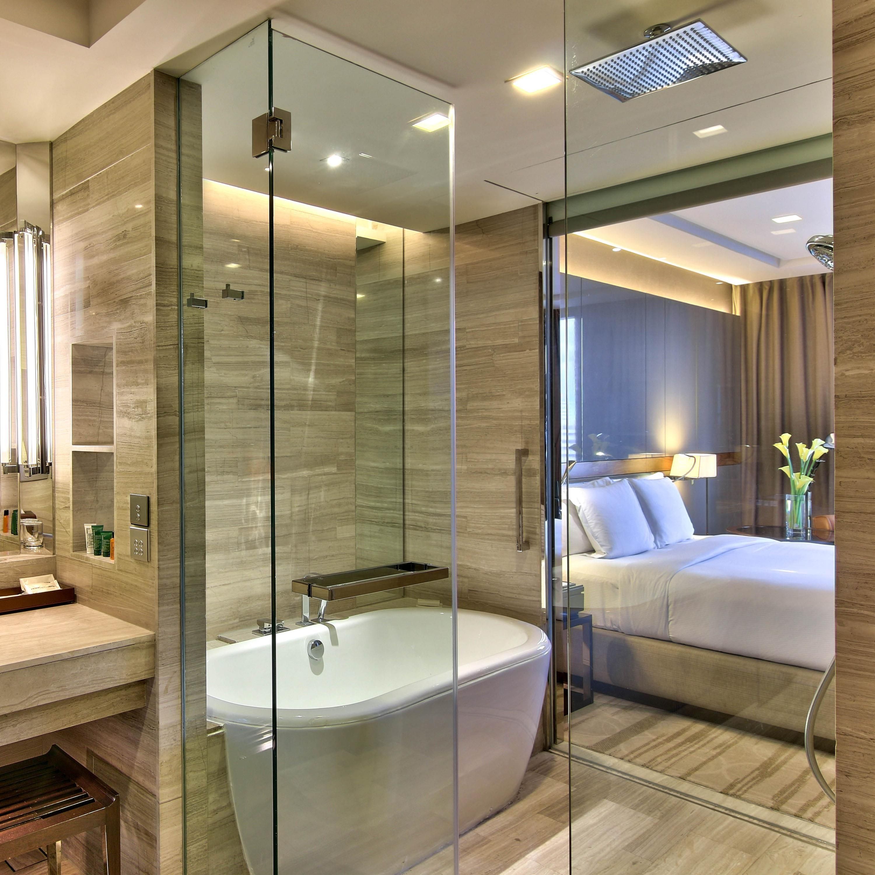 A modern bathroom with a glass-enclosed shower, a bathtub, and a vanity with a mirror.