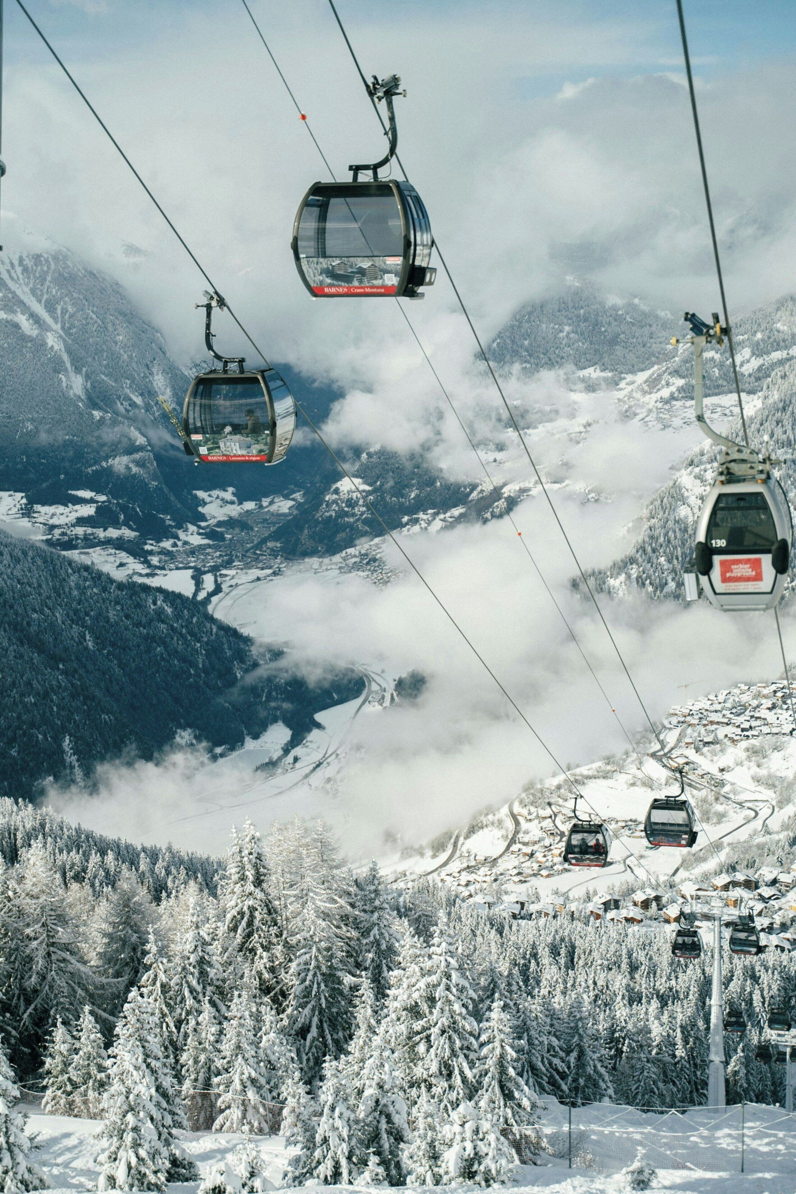 Eine Seilbahnanlage in einer verschneiten Berglandschaft mit freiem Blick ins Tal.