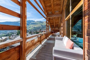 A wooden balcony with a view of a town and mountains. - W Verbier (Bagnes)
